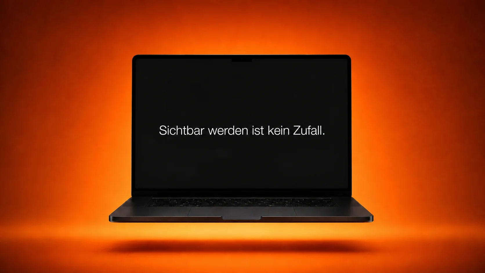 Laptop vor orangefarbenem Hintergrund mit dem weißen Text Sichtbar werden ist kein Zufall.